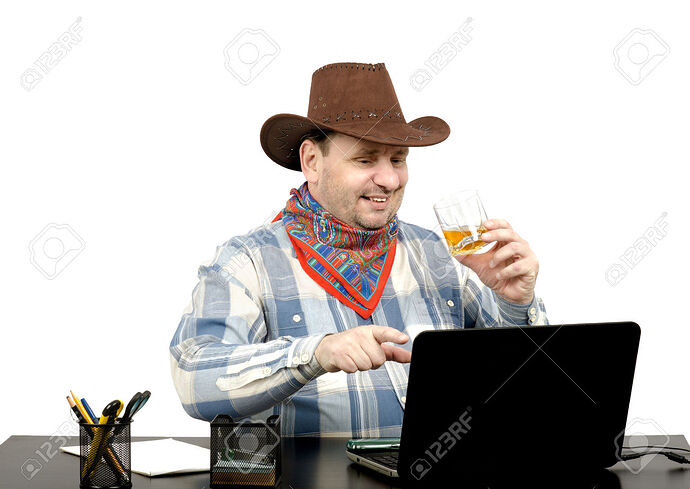 29044789-Cowboy-watching-something-funny-on-the-Internet-on-his-laptop-screen-Stock-Photo