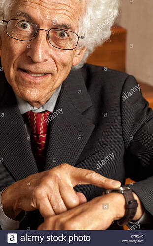 impatient-old-man-pointing-at-his-watch-looking-at-camera-with-a-look-KYR2W0